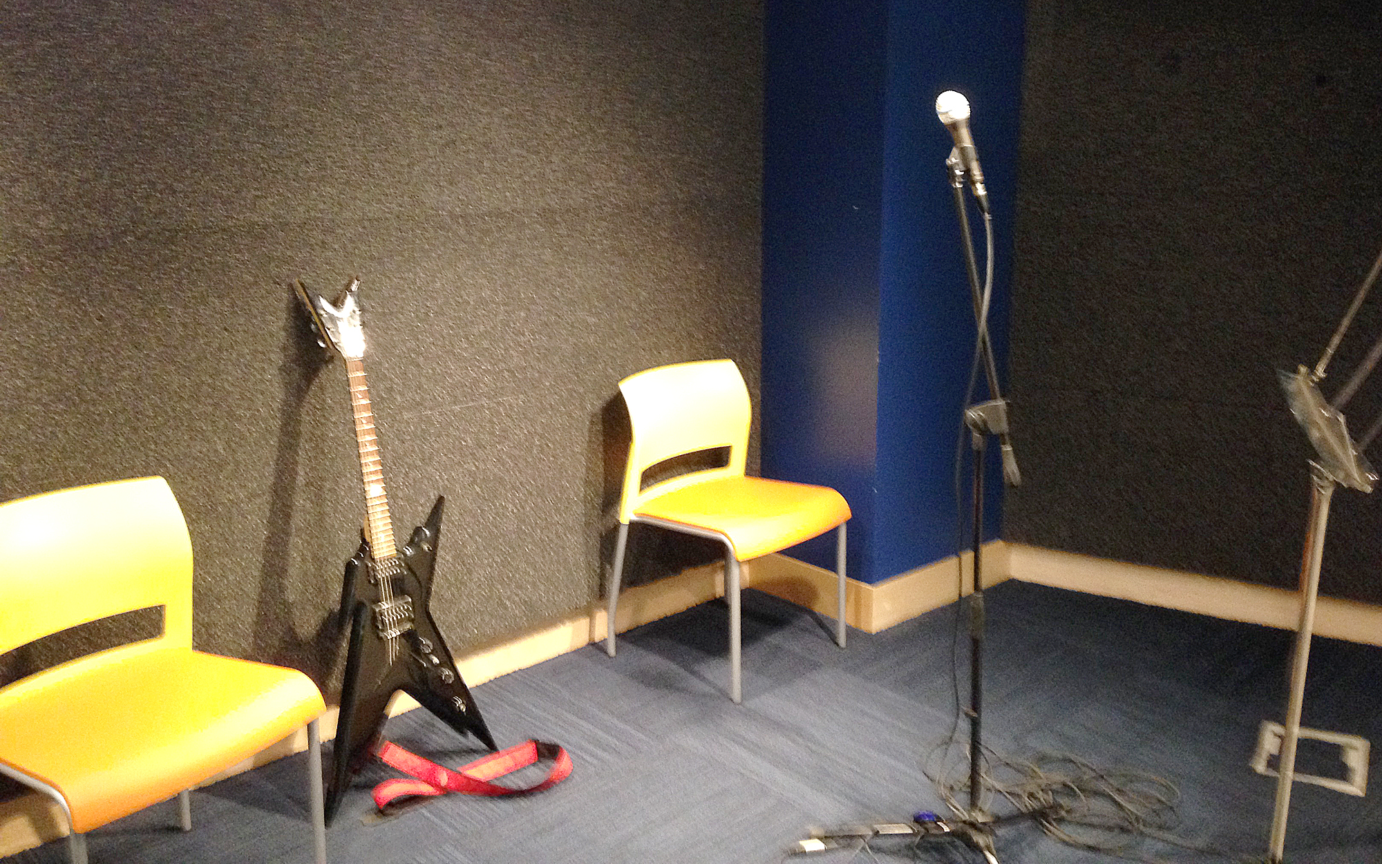 a microphone and a guitar near two chairs